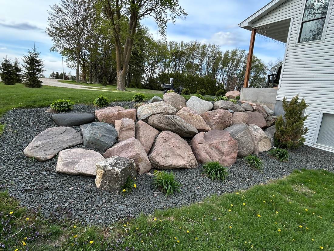Boulder landscape retaining feature near a house