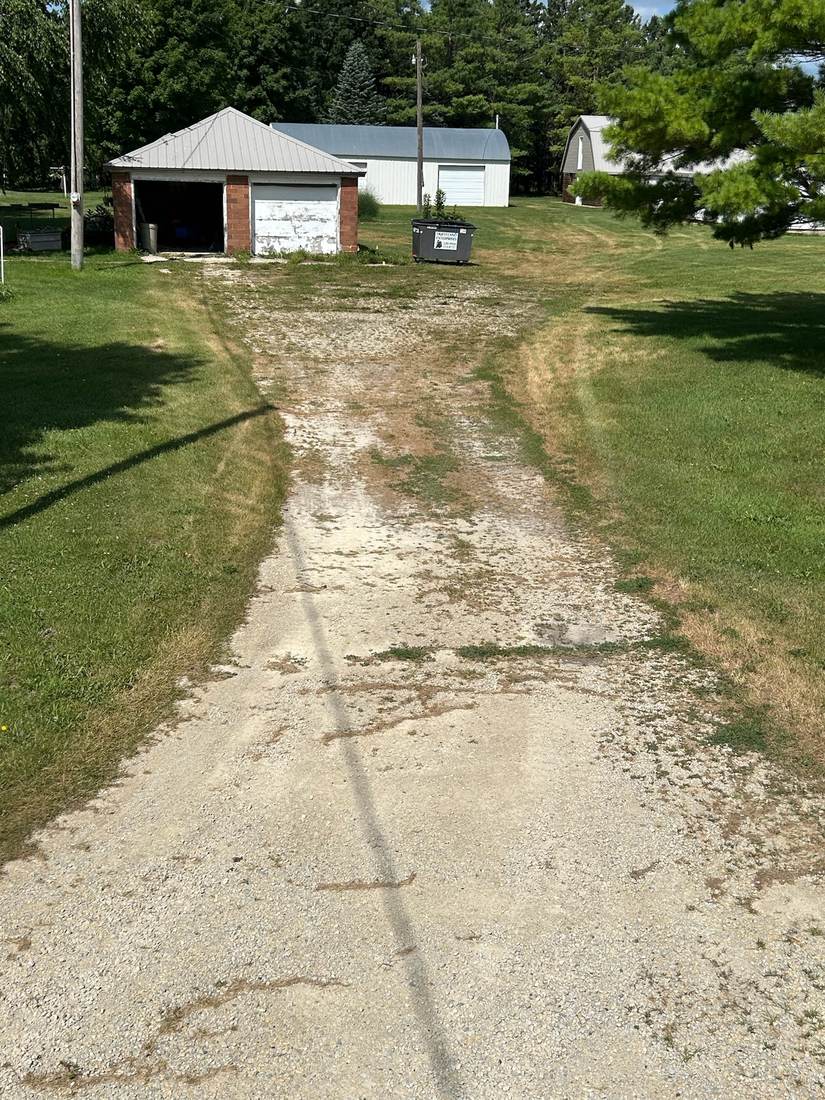 Gravel driveway before revitalization, worn and patchy