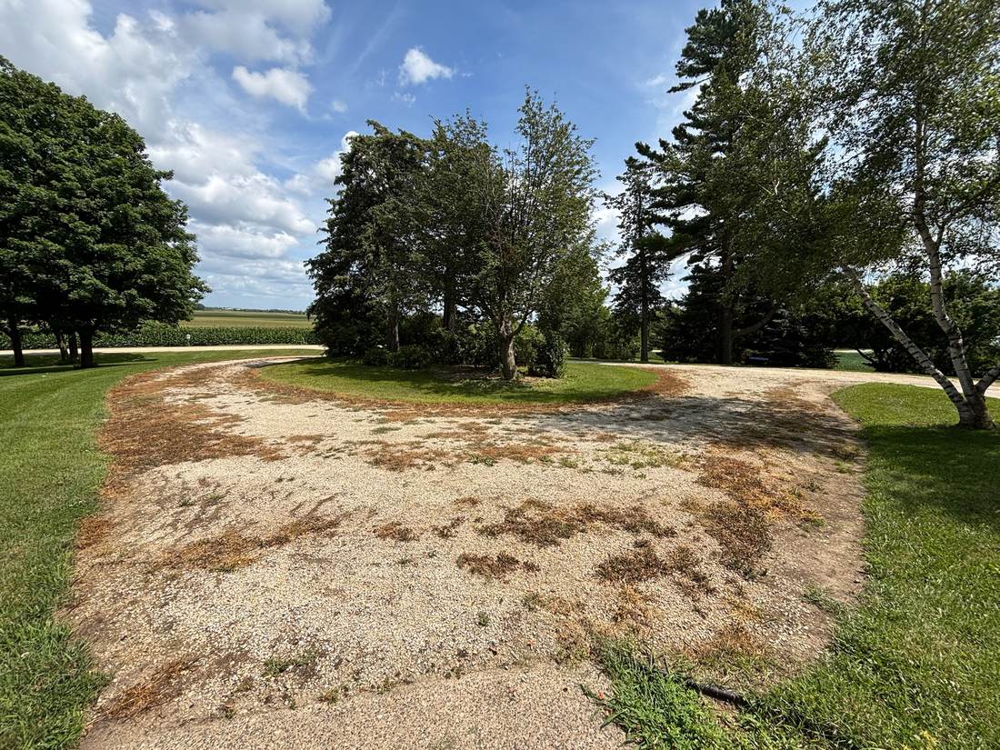 Circular driveway before revitalization, worn and patchy, angle two