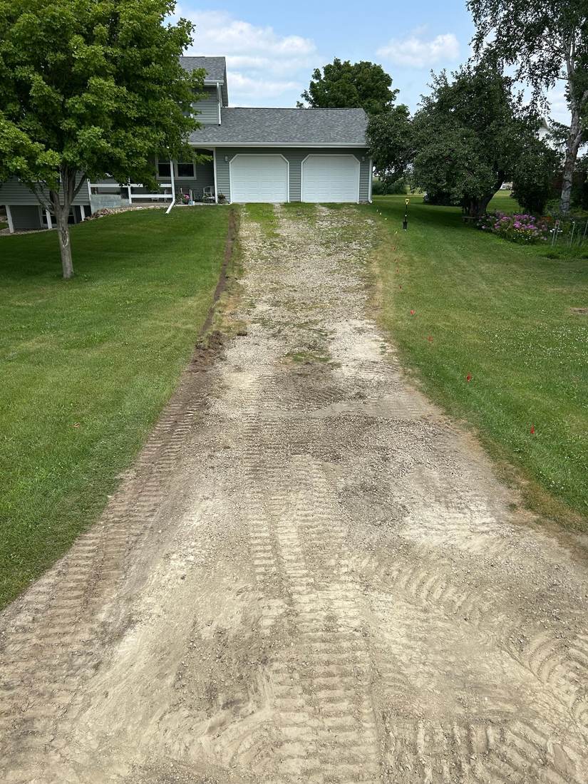 Two-car garage driveway before revitalization, torn up gravel