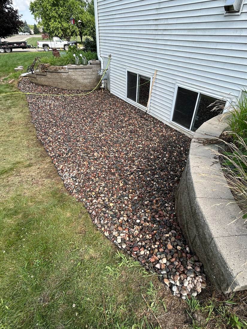 Finished drainage rock bed along house foundation